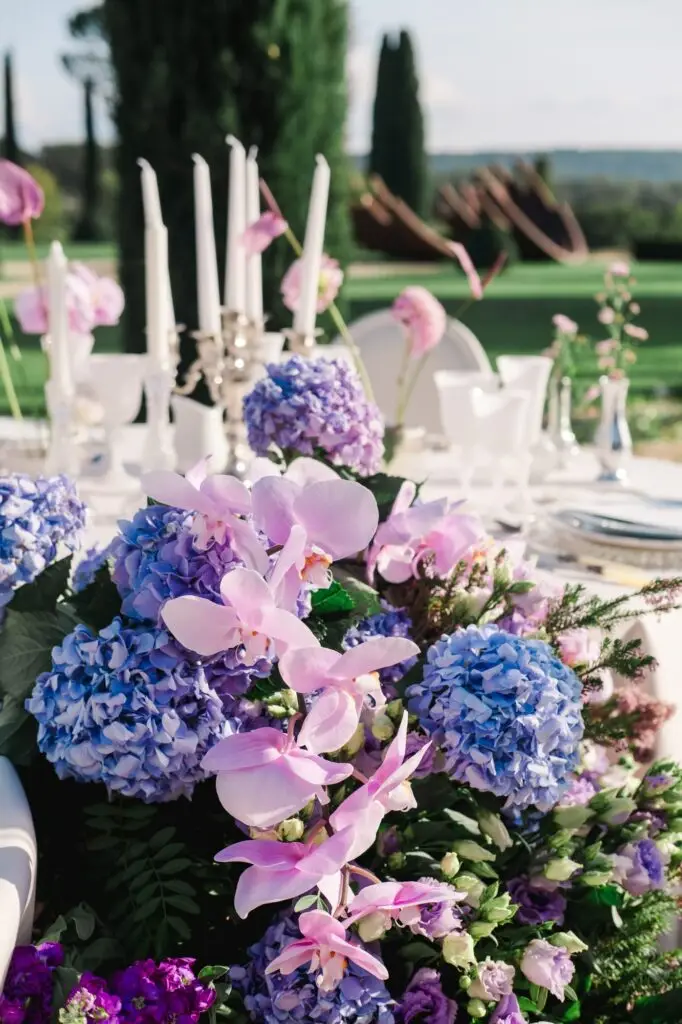 Luxury floral design featuring purple hydrangeas and pink orchids at Château de la Gaude, Provence wedding captured by Julien Boyer, French wedding photographer.