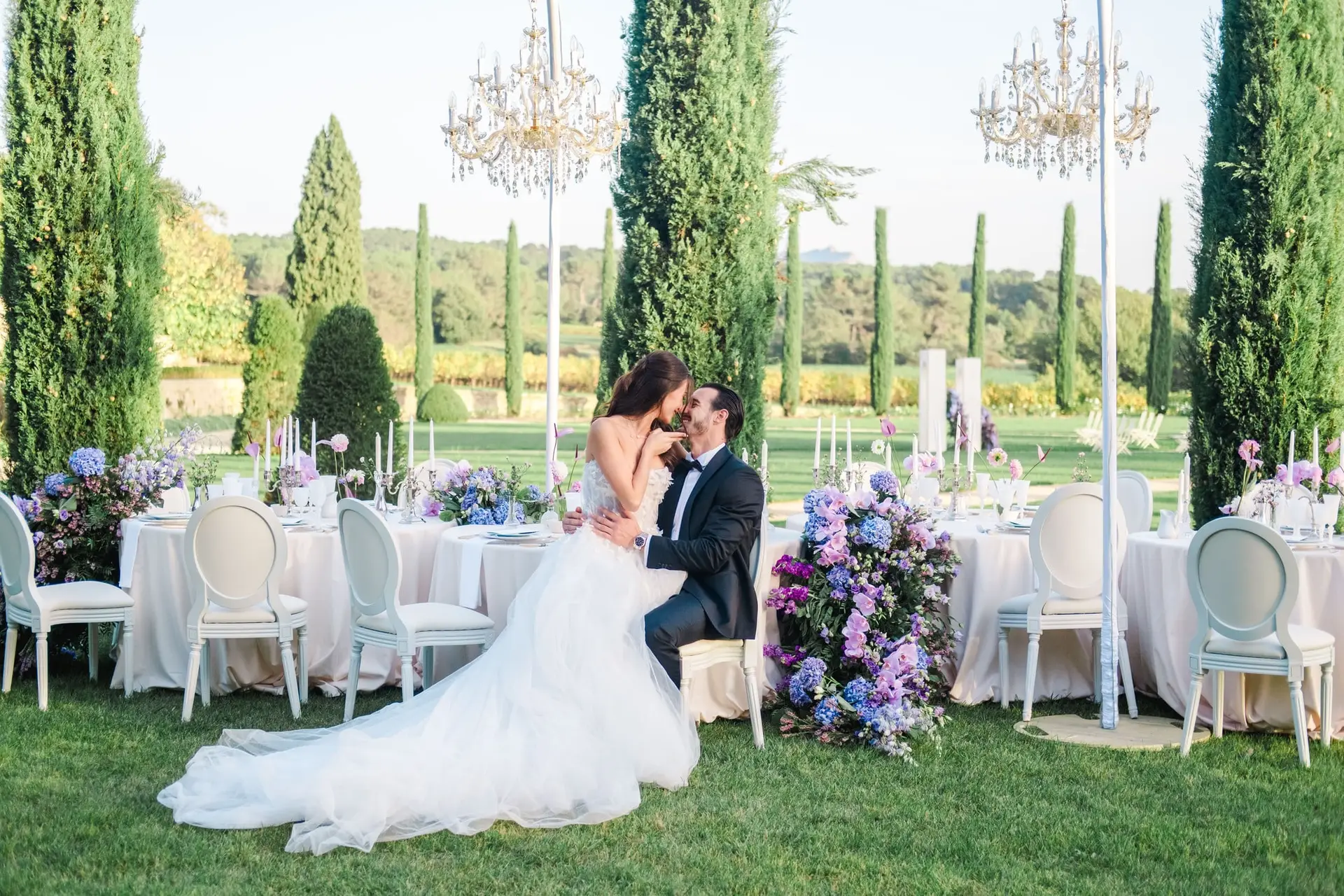 Luxury Provence wedding reception at Château de la Gaude, with the bride and groom sharing a moment among purple floral décor, photographed by Julien Boyer, French wedding photographer