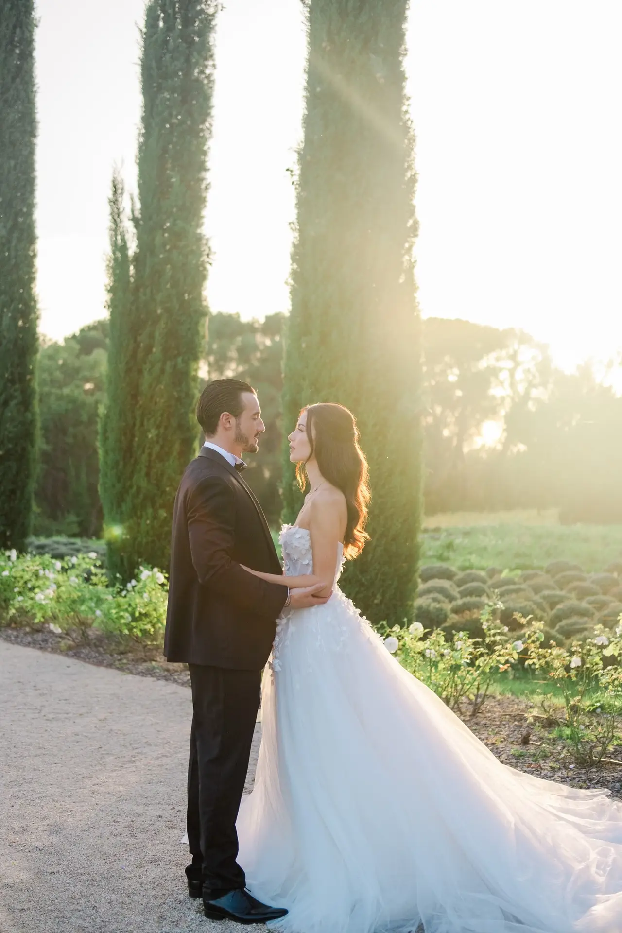 Bride and groom holding hands in a garden at sunset at Château de la Gaude