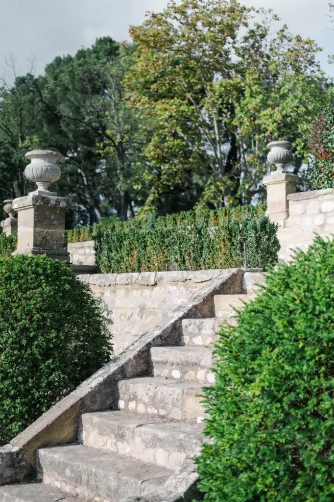 Stone staircase with classical urns and manicured greenery at Château de la Gaude