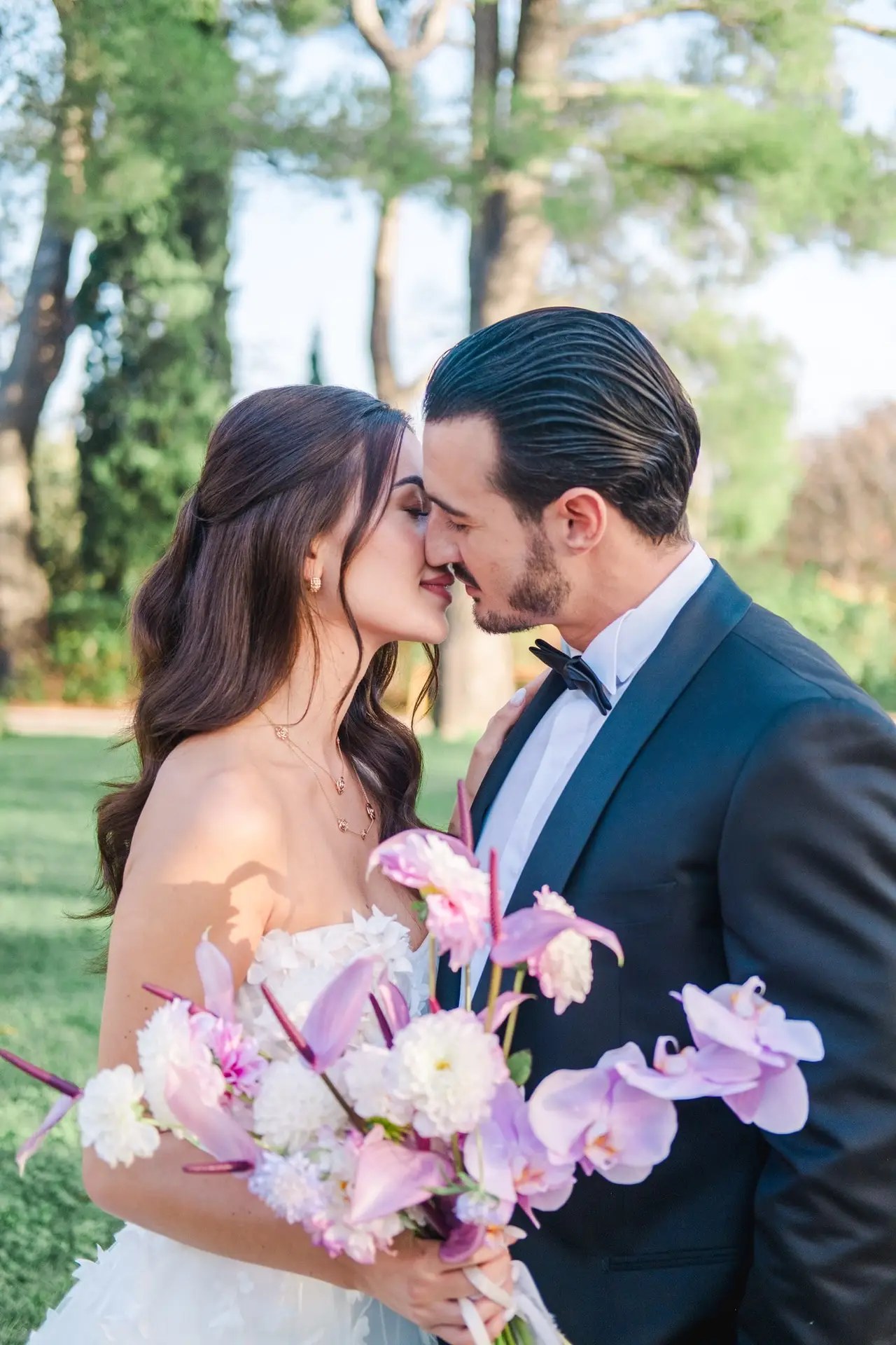 Romantic Provence wedding couple kiss at Château de la Gaude with purple floral bouquet, photographed by Julien Boyer, French wedding photographer