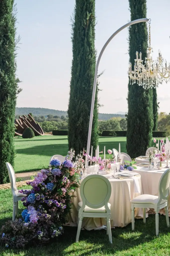 Luxury Provence wedding table setting with fine china, candles, and purple floral design at Château de la Gaude, photographed by Julien Boyer, French wedding photographer.