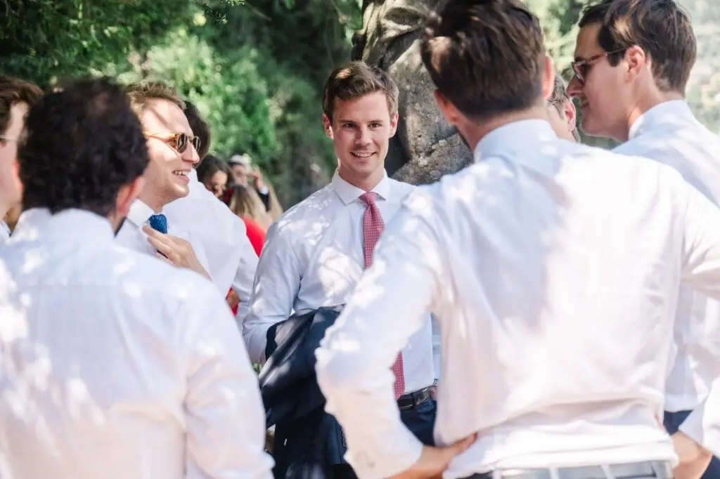 A groom’s party in white shirts and ties, sharing a laugh together before the ceremony.