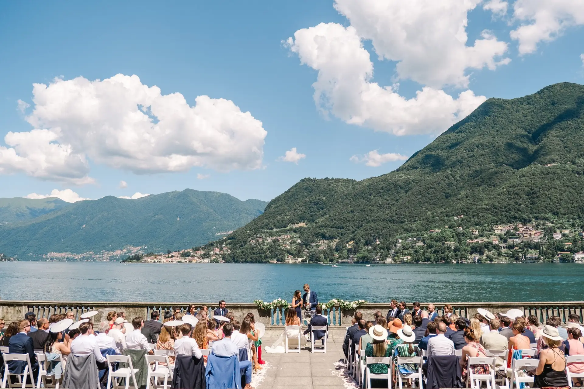 An unforgettable ceremony moment: the couple stands together at the altar with the lake and mountains as a backdrop.
