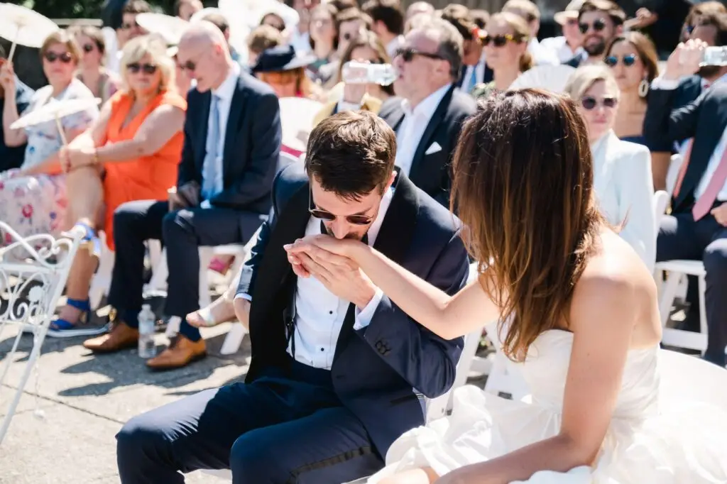 Groom tenderly kissing the bride’s hand during the wedding ceremony at Villa Pizzo, Lake Como.