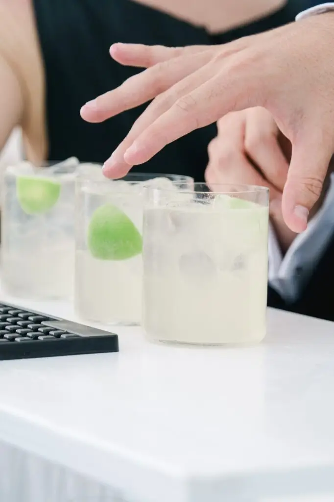 Refreshing cocktails with lime and ice being served at the wedding reception bar.