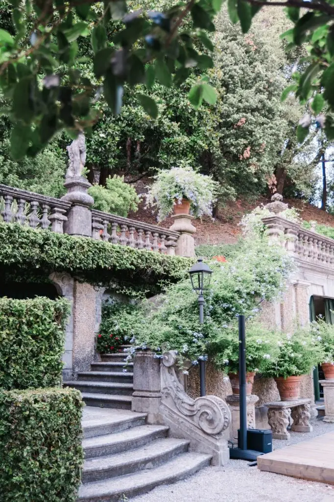 Scenic stone staircase and lush gardens of Villa Pizzo, Italy, decorated with blooming flowers and greenery.