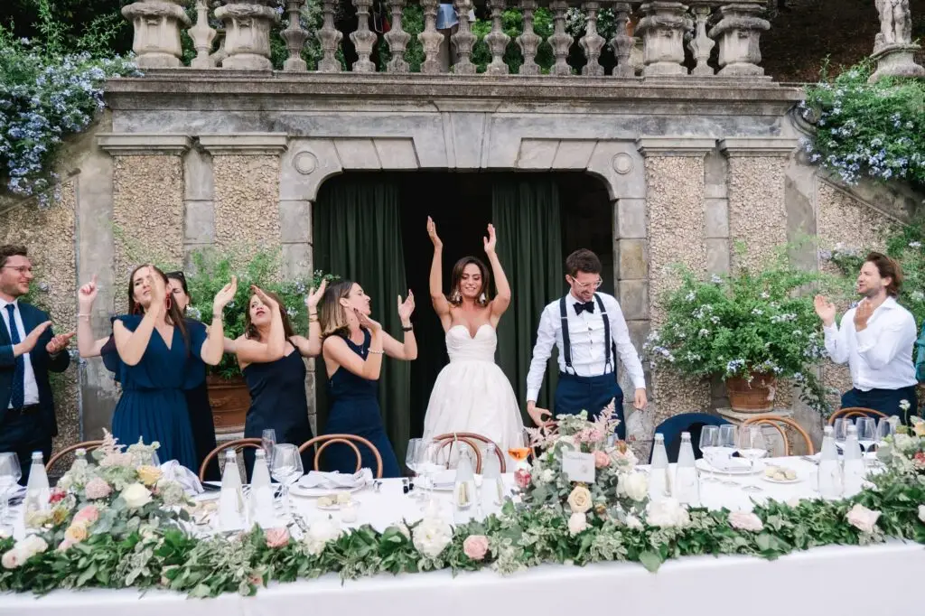 Bride and groom entering the reception with guests clapping and cheering, captured by Julien Boyer, French wedding photographer.