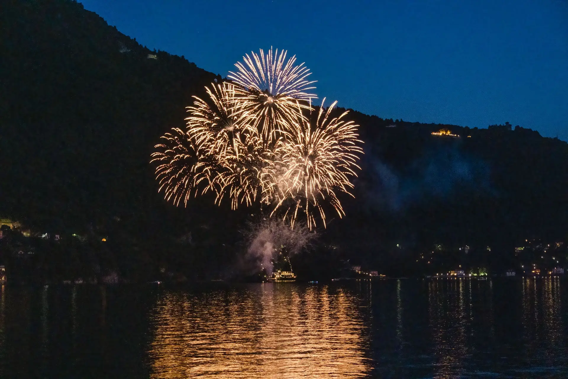 Fireworks lighting up the night sky above Lake Como, marking the perfect ending to a wedding celebration.