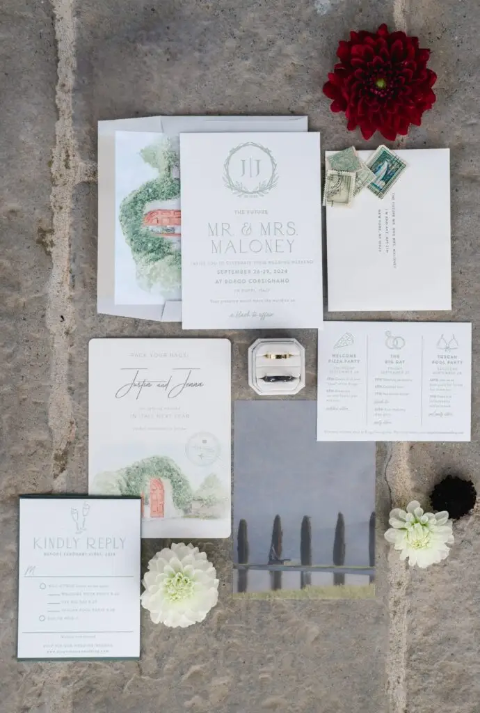 Elegant flat lay of wedding invitations, stationery, and rings for a destination wedding at Borgo Corsignano in Tuscany, Italy.