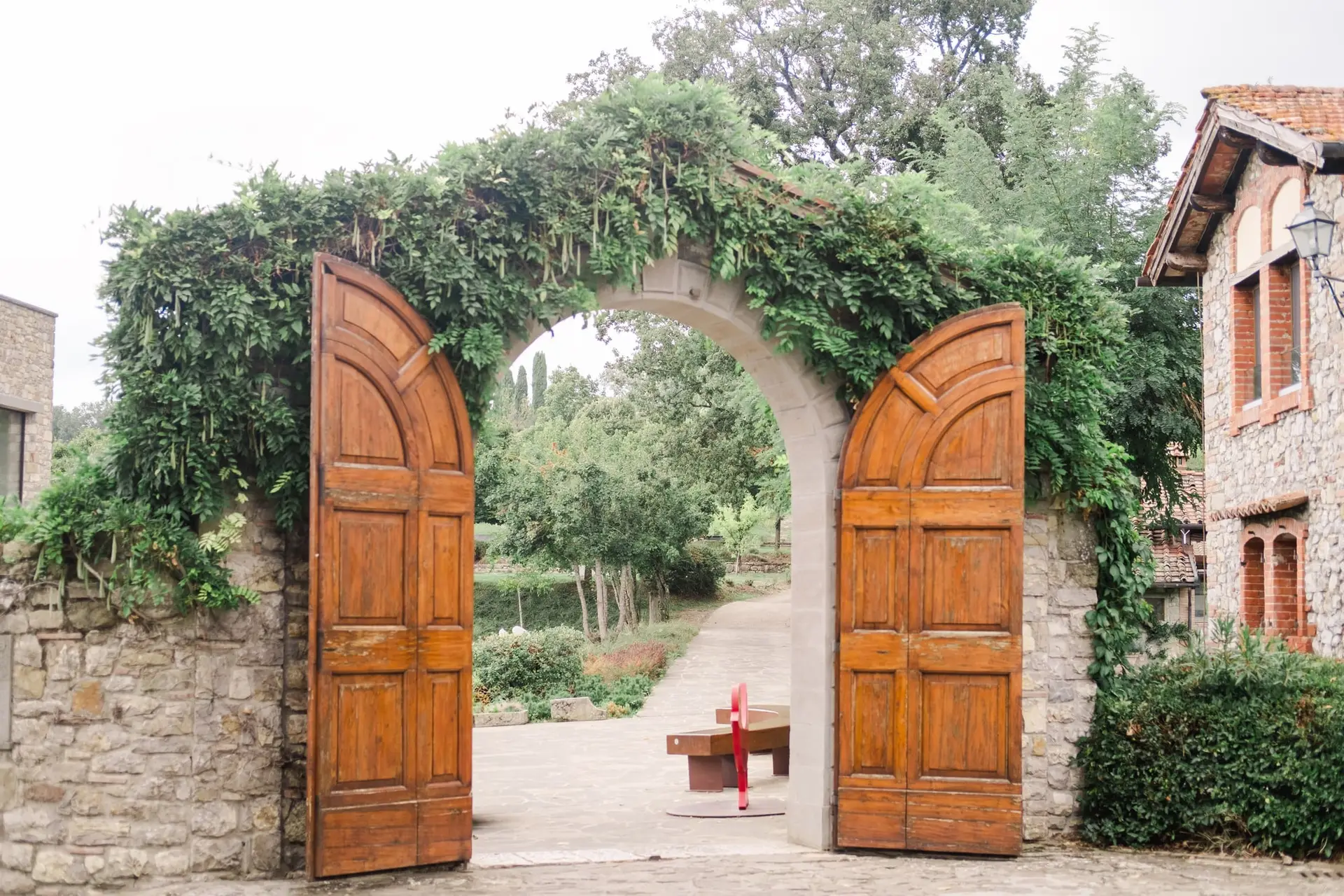 Rustic stone archway with wooden doors at Borgo Corsignano wedding venue in Tuscany, Italy – perfect romantic entrance for a destination wedding.