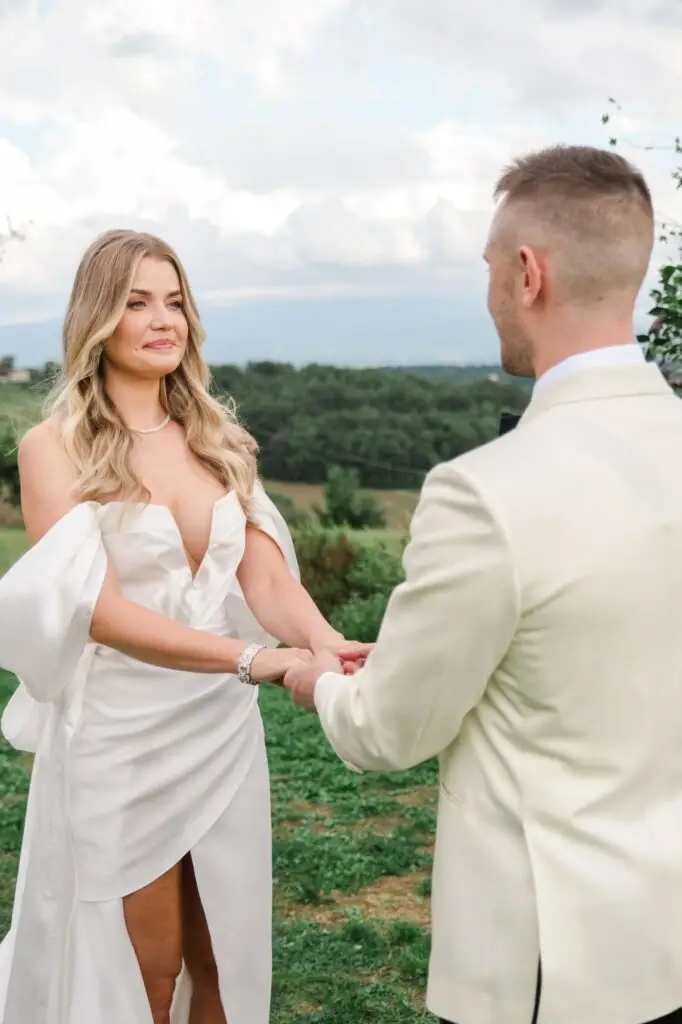 Close-up of the bride holding the groom’s hands, visibly emotional during the luxurious ceremony in Tuscany.