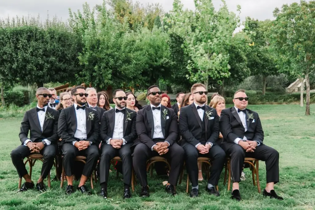 Groomsmen in classic black tuxedos and bow ties, exuding timeless style at the luxury wedding in Tuscany.
