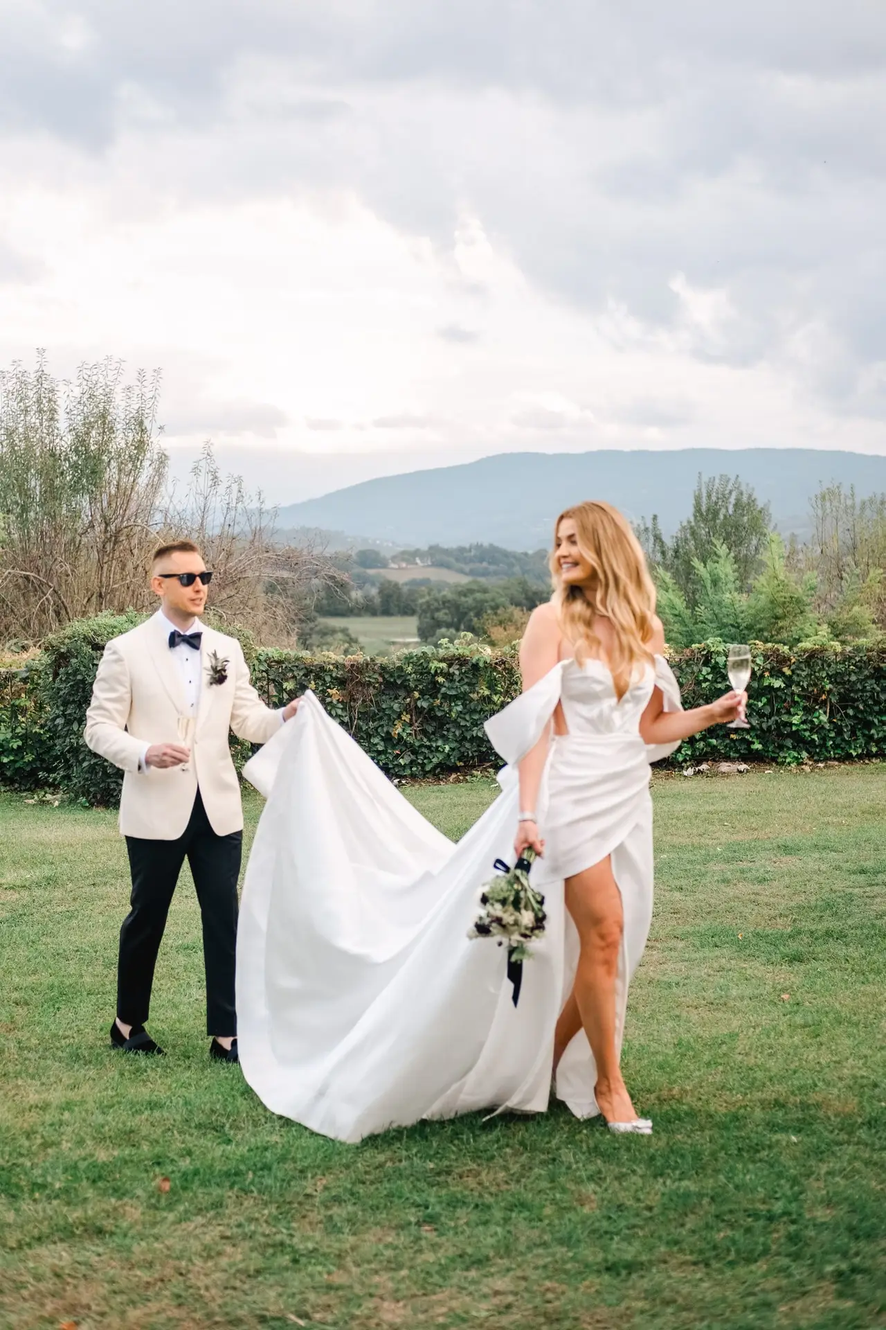 Romantic moment of the bride and groom walking across the Tuscan countryside at Borgo di Corsignano, photographed by Julien Boyer.