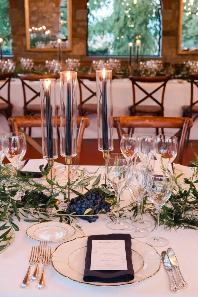Elegant dinner setup with candles, greenery, and glassware creating a luxurious atmosphere at Borgo di Corsignano, photographed by Julien Boyer.