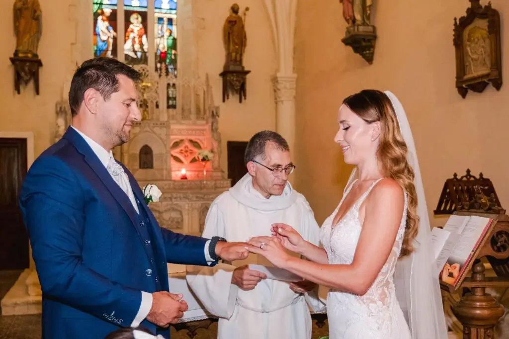 La mariée passe l’alliance au doigt du marié pendant la cérémonie.