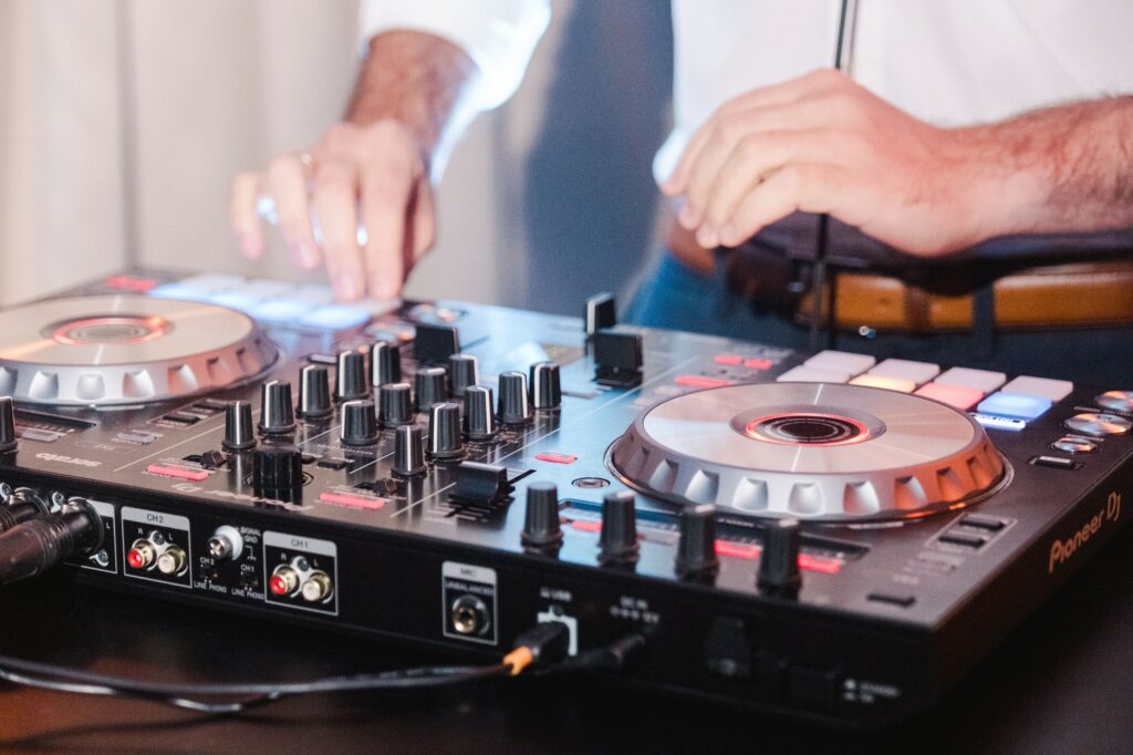 DJ jouant de la musique lors d’un mariage à Bordeaux, utilisant un contrôleur DJ moderne pour assurer l’animation musicale. Il accompagne les mariés et leurs invités dans une ambiance festive.
