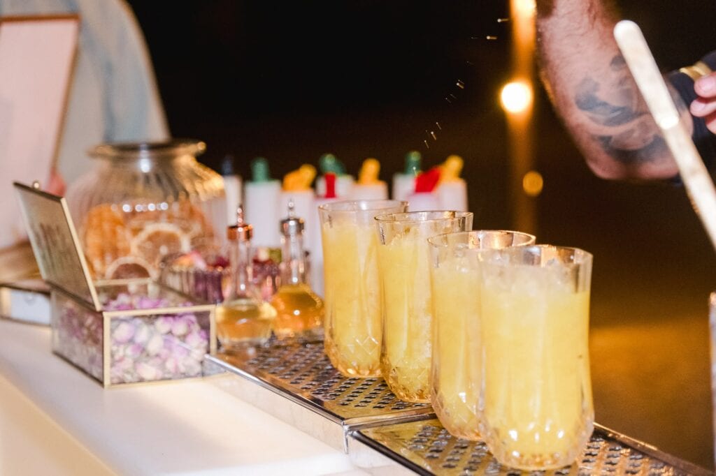 Photo de verres de cocktails lumineux et décorations de mariage dans une ambiance chaleureuse.