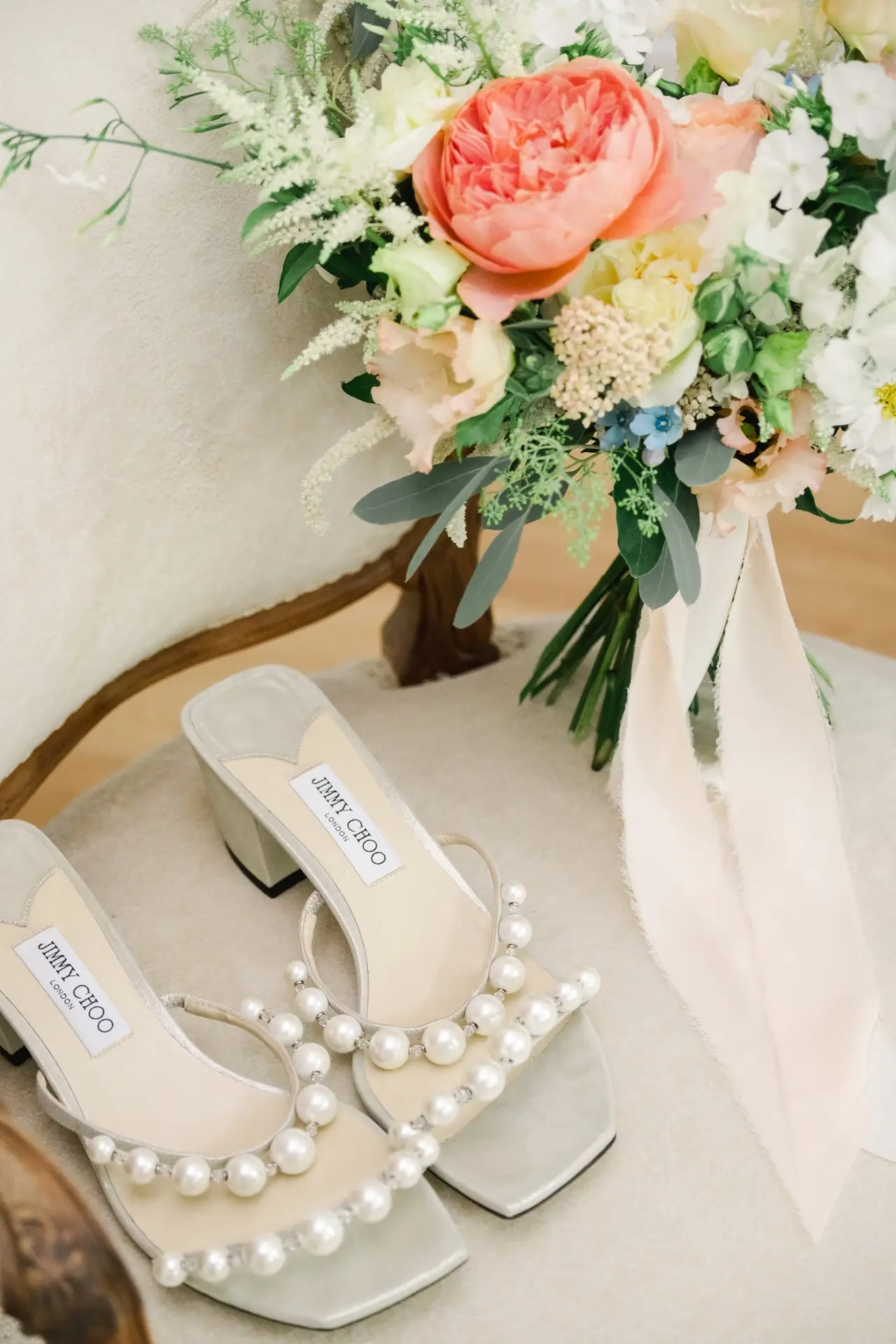 Chaussures de mariée et bouquet de fleurs pastel lors des préparatifs au Château Gassies à Bordeaux.
