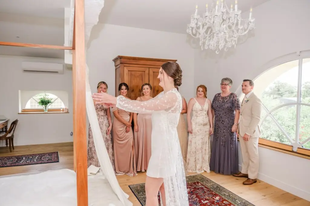 Mariée présentant sa robe à ses proches lors des préparatifs au Château Gassies à Bordeaux.