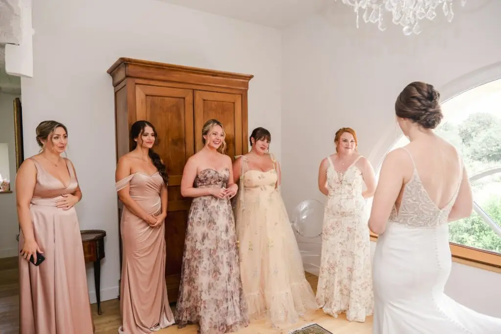 Demoiselles d’honneur admirant la mariée lors des préparatifs au Château Gassies près de Bordeaux.