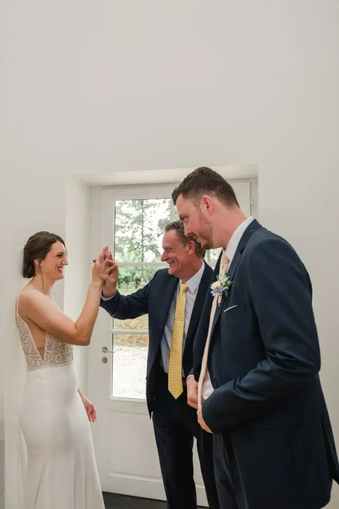 Moment de complicité entre la mariée, le marié et le père lors des préparatifs de mariage au Château Gassies à Bordeaux.
