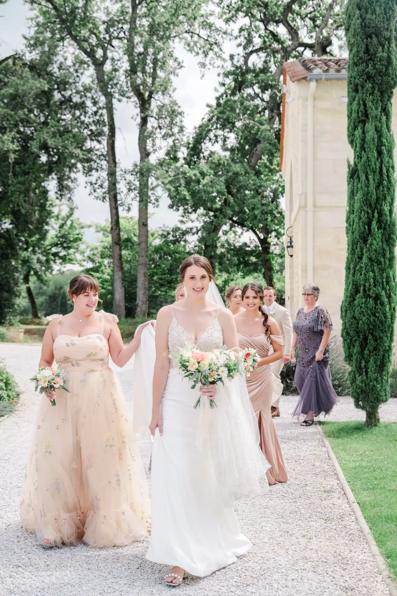 Mariée avançant vers la cérémonie entourée de ses demoiselles d’honneur au Château Gassies à Bordeaux.