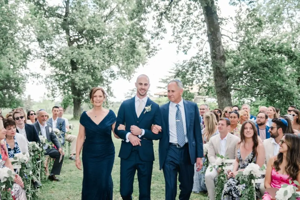 Marié entrant dans l’allée de la cérémonie accompagné de ses parents au Château Gassies à Bordeaux.