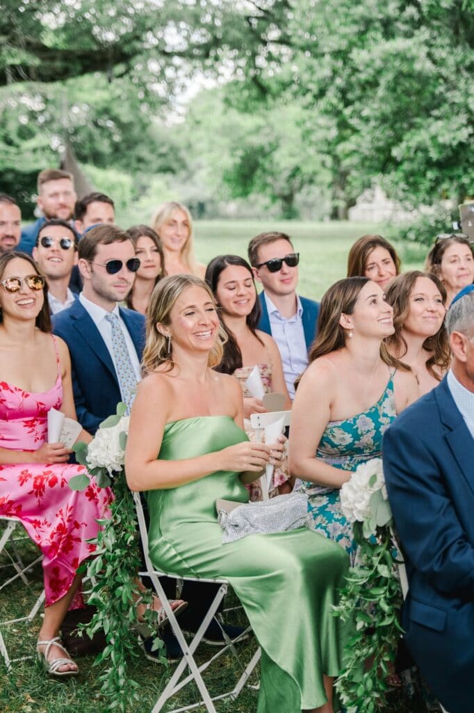Demoiselles d’honneur assises avec leurs bouquets pendant la cérémonie de mariage au Château Gassies à Bordeaux.