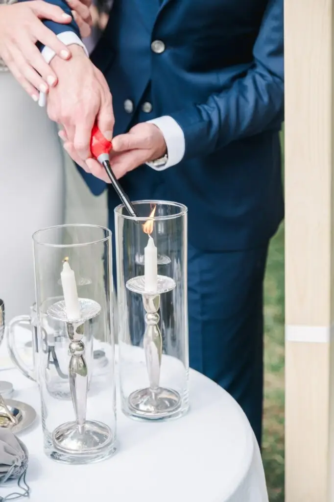 Les mariés allumant une bougie ensemble lors d’un rituel symbolique pendant la cérémonie au Château Gassies à Bordeaux.