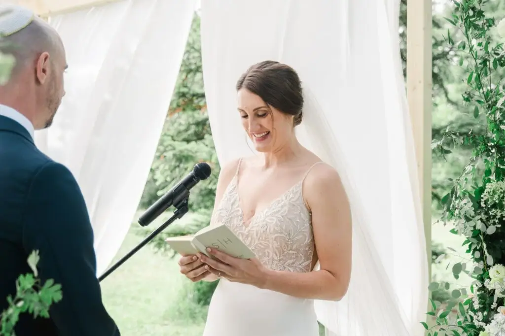 Mariée lisant ses vœux au micro pendant la cérémonie de mariage au Château Gassies à Bordeaux.