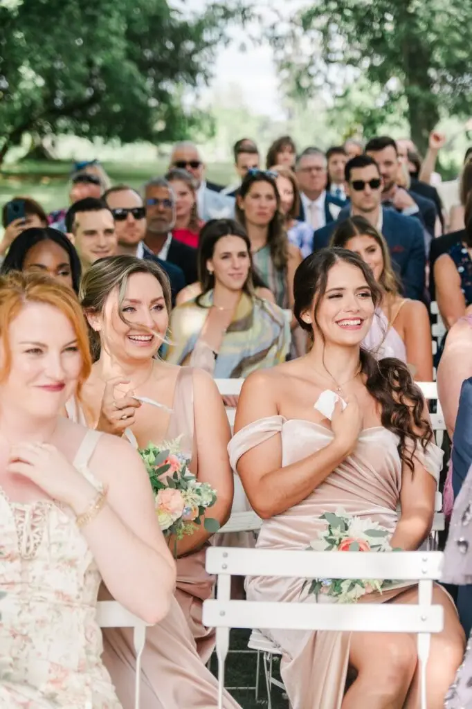 Invités souriant et émus pendant l’échange des vœux lors d’un mariage au Château Gassies à Bordeaux.