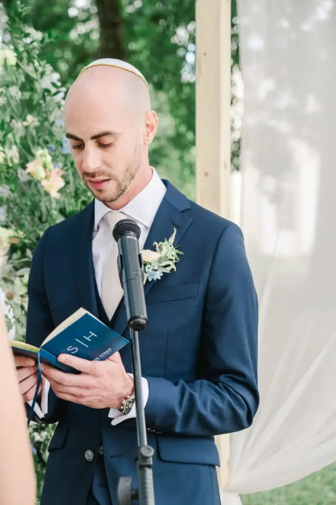 Marié lisant ses vœux au micro lors de la cérémonie de mariage au Château Gassies à Bordeaux.
