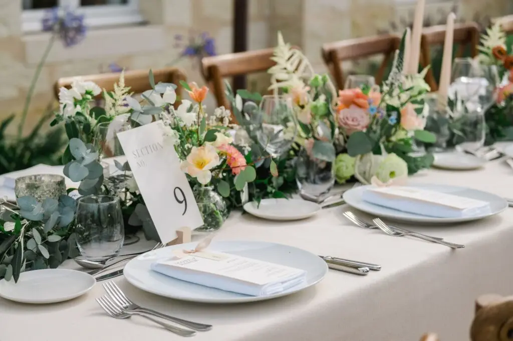 Table de réception de mariage décorée de fleurs, bougies et vaisselle élégante avec numéro de table