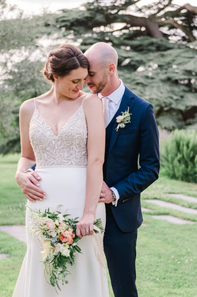 Gros plan intime des mariés partageant un moment de tendresse dans le parc du Château Gassies à Bordeaux