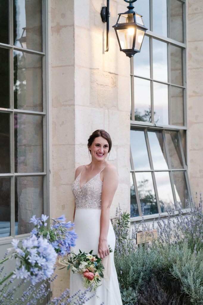 Portrait de la mariée en robe de mariage dans les jardins fleuris du Château Gassies à Bordeaux