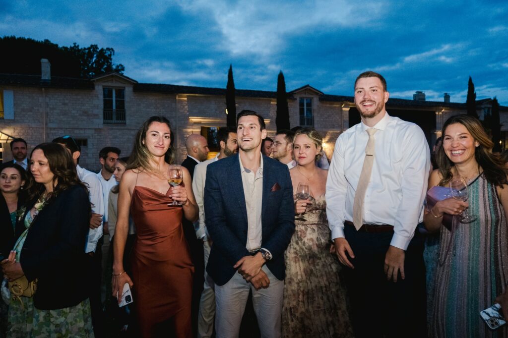 Groupe d’invités réunis et souriants pendant la soirée de mariage au château Gassies
