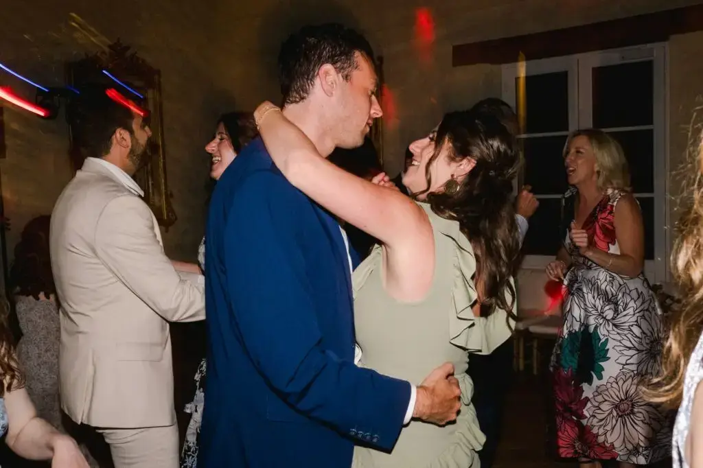Un couple d’invités danse rapproché sur la piste de danse pendant la soirée du mariage.