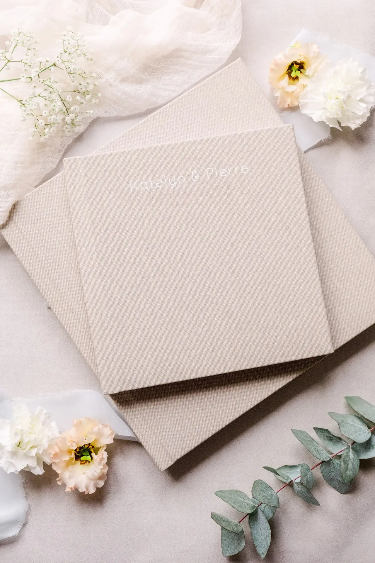 votre album pour votre mariage qui est posé à côté des fleurs sur un tapis en velour