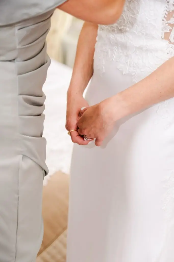 Gros plan sur les mains de la mariée et ses alliances pendant les préparatifs au Château Pape Clément, reportage mariage par Julien Boyer