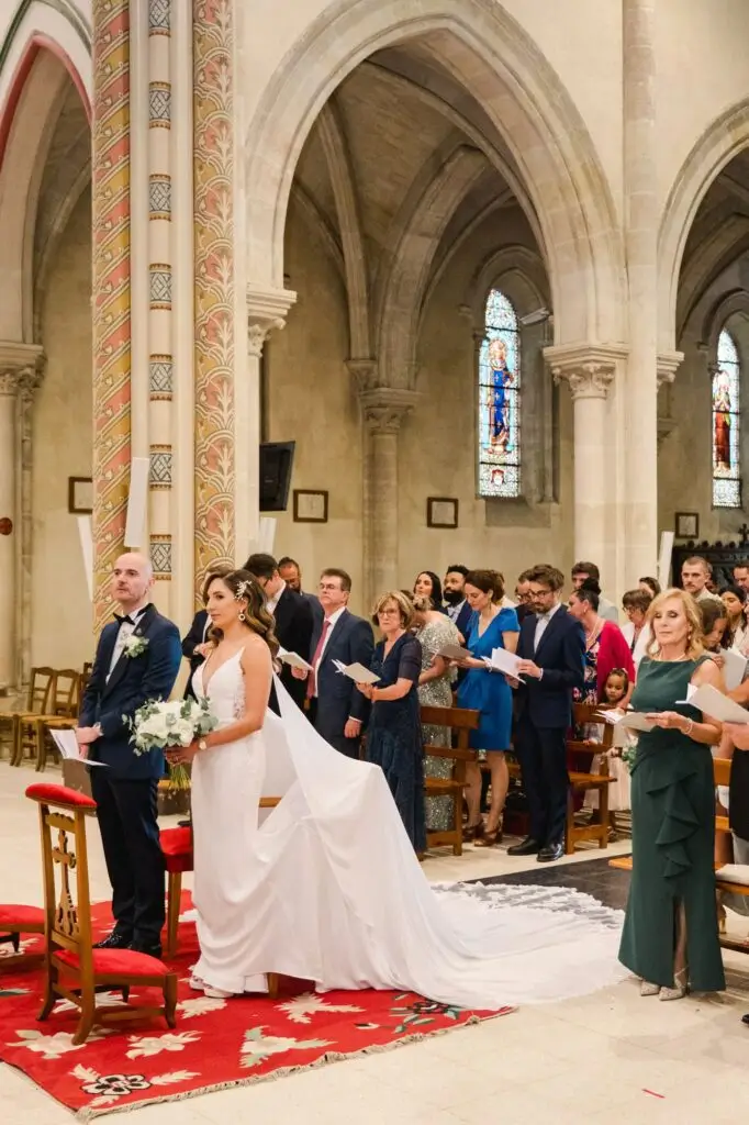 Les mariés debout devant l’autel de l’église de Caudéran à Bordeaux pendant la cérémonie de mariage, entourés de leurs proches, photo Julien Boyer