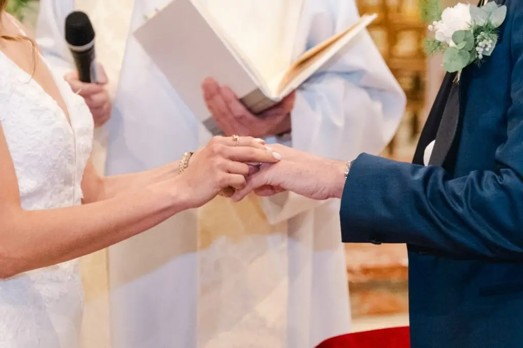 Gros plan sur l’échange des alliances lors du mariage à l’église de Caudéran à Bordeaux, capturé par Julien Boyer photographe de mariage