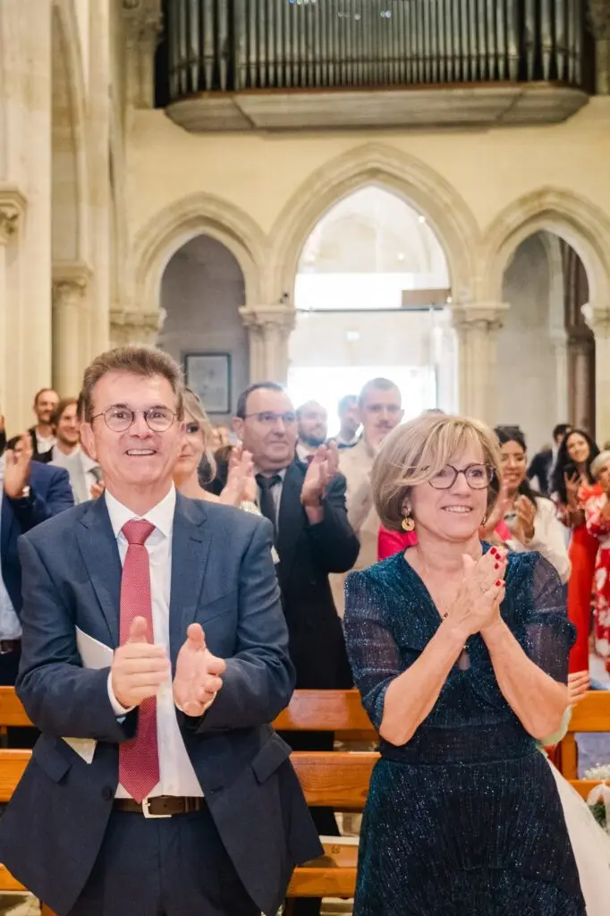 Invités applaudissant avec émotion à la fin de la cérémonie de mariage dans l’église de Caudéran à Bordeaux, photo par Julien Boyer photographe de mariage