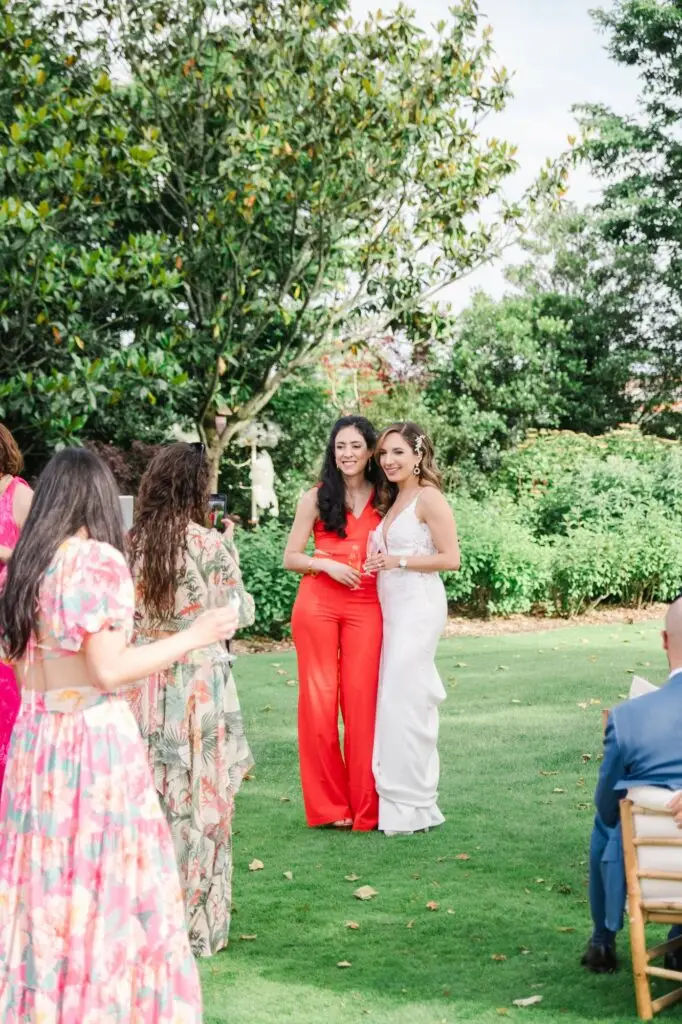 La mariée pose avec une invitée pendant le cocktail de mariage dans les jardins du Château Pape Clément à Pessac, photo par Julien Boyer