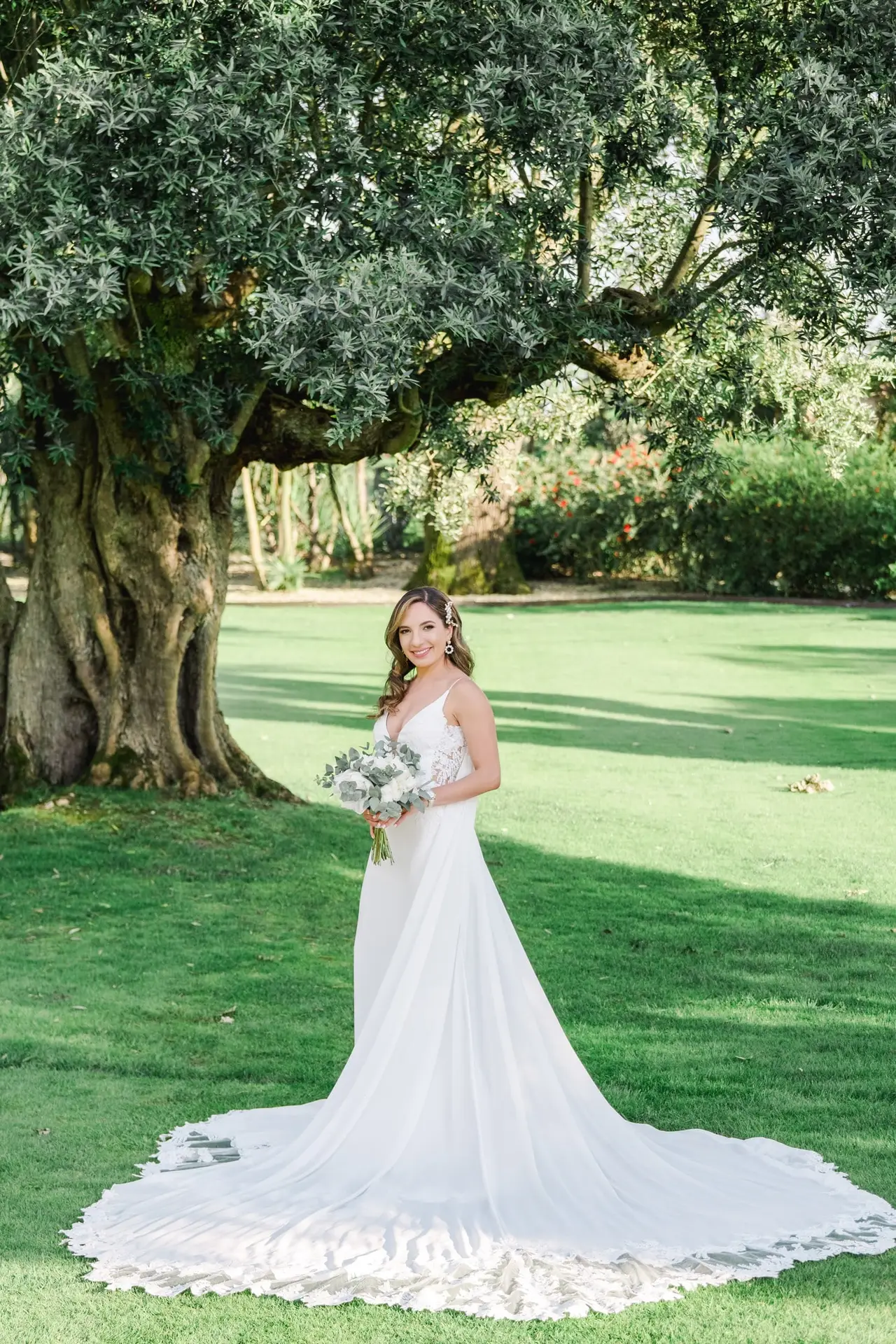Portrait de la mariée en robe de mariage tenant son bouquet dans les jardins du Château Pape Clément à Pessac, photo par Julien Boyer photographe de mariage