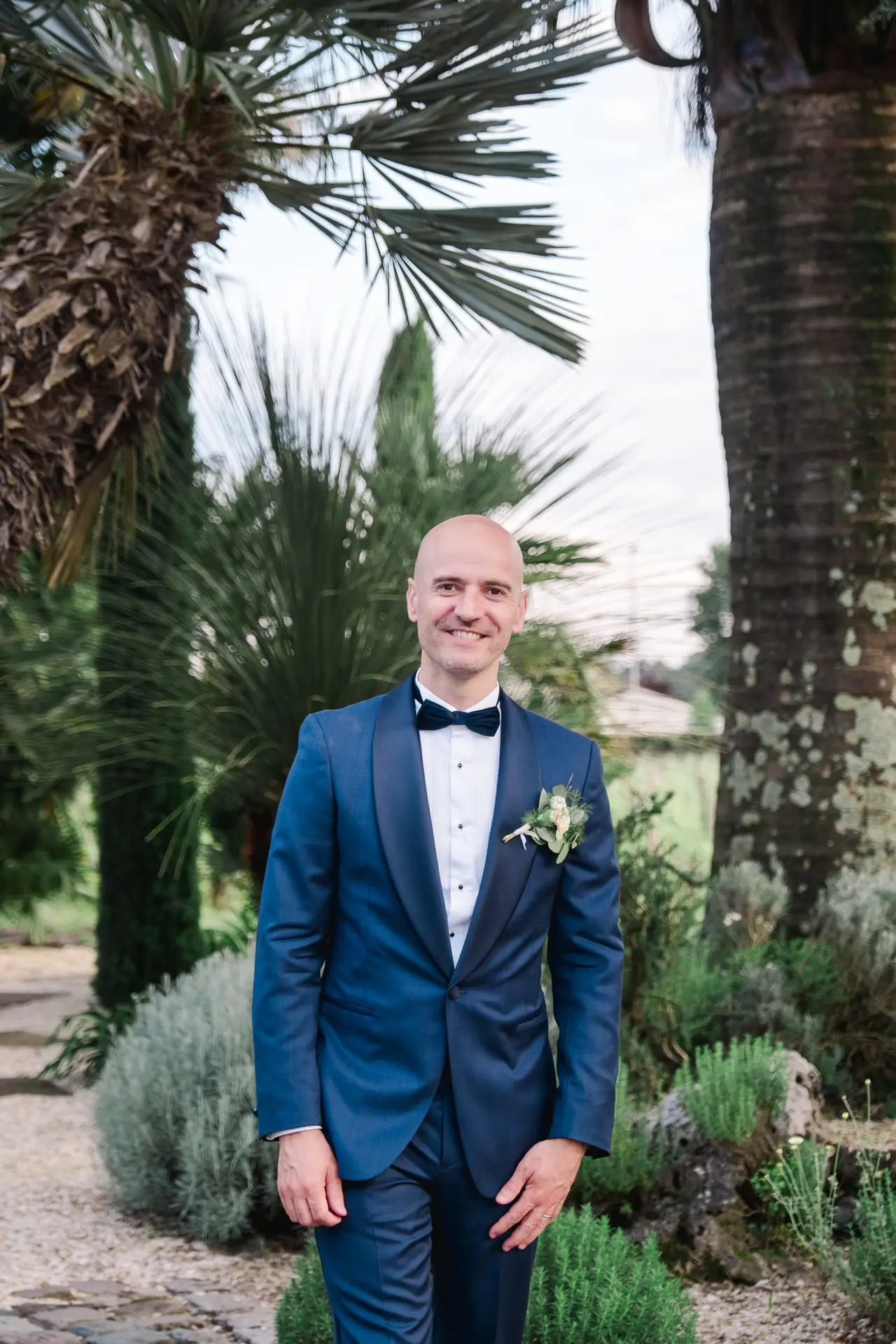 Portrait du marié en costume bleu dans les jardins du Château Pape Clément à Pessac lors de la séance photo de mariage, photo Julien Boyer