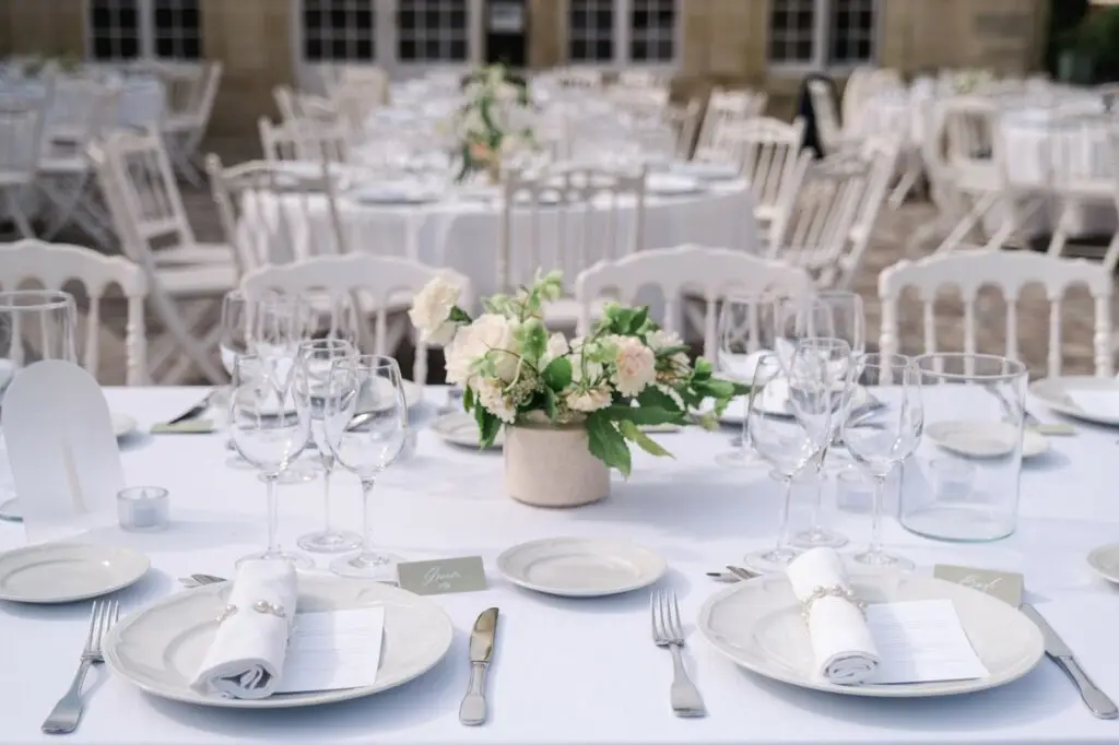 Détails de la décoration de table pour le dîner de mariage au Château Pape Clément à Pessac, vaisselle élégante et fleurs blanches, photo Julien Boyer