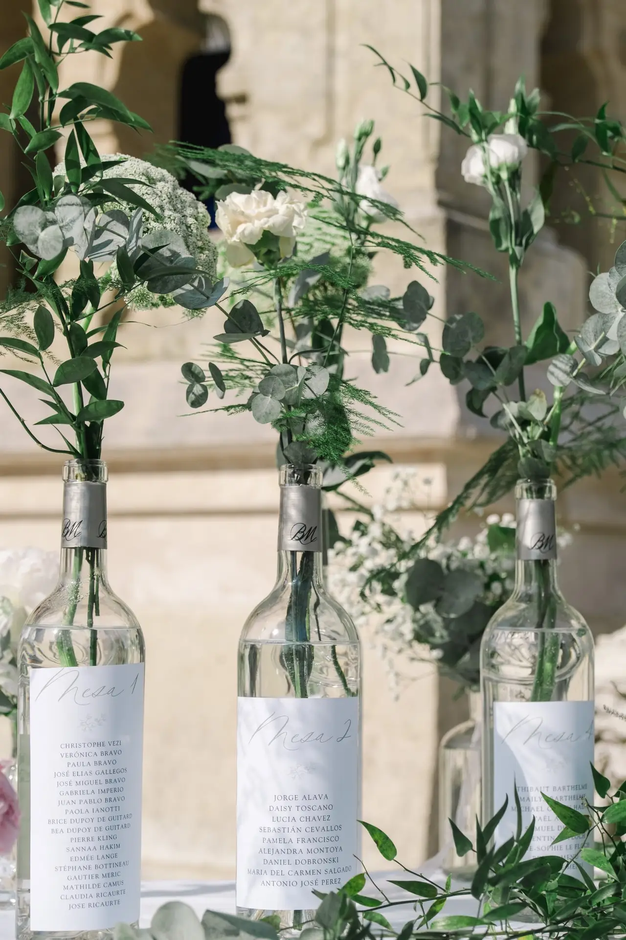 Détail du plan de table de mariage avec fleurs blanches et feuillage dans la cour du Château Pape Clément à Pessac, photo Julien Boyer