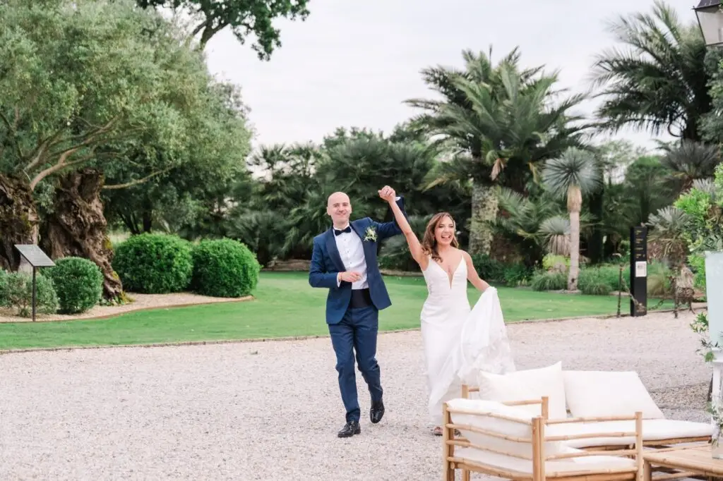 Les mariés font leur entrée dans l’espace de réception en extérieur au Château Pape Clément à Pessac, photo de mariage par Julien Boyer