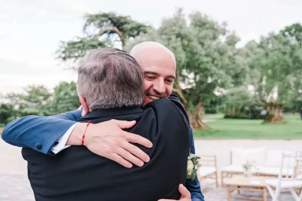 Le marié échange une étreinte pleine d’émotion avec un proche lors de la réception de mariage au Château Pape Clément à Pessac, photo Julien Boyer